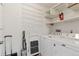 Bright laundry room with storage shelves and modern washer and dryer units at 14390 E Marina Dr # 601, Aurora, CO 80014