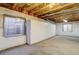 Partially finished basement featuring built-in storage cabinets and an egress window at 2608 S Troy Ct, Aurora, CO 80014