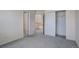 A bedroom with neutral walls, carpeted floors, and multiple closets at 2608 S Troy Ct, Aurora, CO 80014