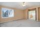 A bright bedroom with a large window, neutral walls, and carpeted floor at 2608 S Troy Ct, Aurora, CO 80014