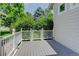 Exterior view of gray wooden deck with white railing and lush greenery at 2608 S Troy Ct, Aurora, CO 80014