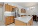 Bright kitchen area featuring light wood cabinets, stainless steel refrigerator, and island counter with seating at 2608 S Troy Ct, Aurora, CO 80014
