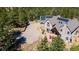 This aerial view showcases a beautiful home with solar panels and a large parking area nestled among lush green trees at 1057 Reed Ranch Rd, Boulder, CO 80302