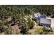 Aerial view shows a home with solar panels, an outdoor fire pit, and a hot tub surrounded by lush greenery at 1057 Reed Ranch Rd, Boulder, CO 80302