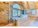 En suite bathroom showcasing a soaking tub next to a large picture window overlooking trees at 1057 Reed Ranch Rd, Boulder, CO 80302