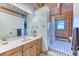 Well-lit bathroom with a wood vanity, large mirror, and a step-in shower with a white shower curtain at 1057 Reed Ranch Rd, Boulder, CO 80302