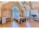 Bright bedroom featuring vaulted wood ceilings, desk, and large windows overlooking trees at 1057 Reed Ranch Rd, Boulder, CO 80302