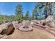 Custom outdoor stone fire pit featuring seating area and mature landscaping at 1057 Reed Ranch Rd, Boulder, CO 80302