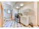 Spacious laundry room featuring stainless steel washer and dryer, tiled floor, and utility sink at 1057 Reed Ranch Rd, Boulder, CO 80302
