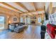 Cozy living room features wood beams, a stone fireplace, and ample natural light at 1057 Reed Ranch Rd, Boulder, CO 80302