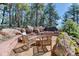 Serene outdoor space featuring comfortable seating and a stone hot tub nestled amongst lush trees and natural rock formations at 1057 Reed Ranch Rd, Boulder, CO 80302