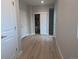 Hallway showing multiple doors, neutral walls, and wood-look flooring, with a glimpse into a utility space at 4737 E Iliff Ave, Denver, CO 80222