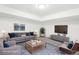 Bright living room features neutral walls, carpet, and a large sectional sofa and television at 224 Agate Way, Broomfield, CO 80020