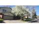 Charming home featuring a well-maintained front yard, a two-car garage, and beautiful flowering tree at 12682 W Louisiana Ave, Lakewood, CO 80228