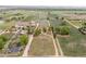 An aerial view of a rural property displaying mature trees, scattered homes, a pond, and expansive land at 6363 County Road 20, Longmont, CO 80504