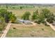 Picturesque aerial view of a sprawling property with mature trees and a residence featuring a circular driveway at 6363 County Road 20, Longmont, CO 80504