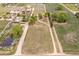 An aerial view of a rural property displaying mature trees, scattered homes, a pond, and expansive land at 6363 County Road 20, Longmont, CO 80504