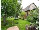 Large backyard with trampoline, mature trees, and stone pathway at 3409-3415 W Moncrieff Pl, Denver, CO 80211