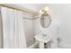 Clean bathroom with white tile, pedestal sink, and gold accents at 3409-3415 W Moncrieff Pl, Denver, CO 80211