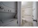 Well-lit bathroom with a shower-tub combo, tiled walls, and safety bars, conveniently located near the laundry at 8330 Zuni St # 214, Denver, CO 80221