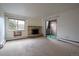 Spacious living room featuring a decorative fireplace, large windows, and sliding glass doors to a private balcony at 8330 Zuni St # 214, Denver, CO 80221
