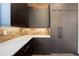 Sleek kitchen with dark cabinetry, white countertops, brick backsplash, and stainless steel refrigerator at 1778 Peak Loop, Broomfield, CO 80023