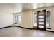 Bright living room with neutral tones, tile flooring, and modern windows surrounding the home's entrance at 1778 Peak Loop, Broomfield, CO 80023