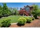 Expansive backyard featuring a lush lawn, a red pergola-covered deck, and meticulous landscaping that provides privacy at 1300 W Caley Ave, Littleton, CO 80120