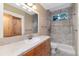 Bathroom with a shower over tub, neutral tiling, and wood vanity at 1300 W Caley Ave, Littleton, CO 80120