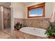 Luxurious bathroom featuring a soaking tub with tile surround and separate glass enclosed shower at 1300 W Caley Ave, Littleton, CO 80120