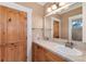 Bathroom featuring a wood vanity and a large mirror at 1300 W Caley Ave, Littleton, CO 80120