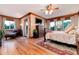 Primary bedroom featuring a ceiling fan, wood floors, deck access, and an ensuite bathroom at 1300 W Caley Ave, Littleton, CO 80120