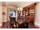 Formal dining room with a large wood table, plush rug, natural light, and wood bookcase at 1300 W Caley Ave, Littleton, CO 80120