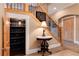 Hallway featuring a wine room, elegant decor, stairs with metal railings, and tile floors at 1300 W Caley Ave, Littleton, CO 80120