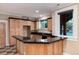 Kitchenette with black countertops, wood cabinets, and a breakfast bar at 1300 W Caley Ave, Littleton, CO 80120