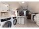 Large laundry room with washer and dryer, storage cabinets and hanging racks at 1300 W Caley Ave, Littleton, CO 80120