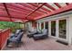 Outdoor patio area with comfortable seating, a red pergola, and a seamless transition from indoor living with multiple doors at 1300 W Caley Ave, Littleton, CO 80120