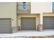 Attached garage with gray door and snow on ground at 453 Interlocken Blvd # 102, Broomfield, CO 80021