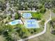 Overhead shot of tennis courts and swimming pool surrounded by trees and neighborhood streets at 7414 S Monroe Ct, Centennial, CO 80122