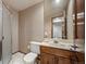 Bathroom featuring a shower, mirror, vanity, tile floor, and patterned wallpaper at 7414 S Monroe Ct, Centennial, CO 80122