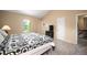 Bright bedroom with large window, vaulted ceiling, and black and white patterned bedspread at 7414 S Monroe Ct, Centennial, CO 80122