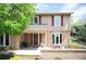 Charming two-story home featuring a brick facade, covered entrance, and mature landscaping at 7414 S Monroe Ct, Centennial, CO 80122