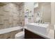 Modern bathroom featuring stylish tile work, a bathtub, and contemporary sink with a decorative glass shelf at 3615 Navajo St, Denver, CO 80211