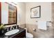 Comfortable bathroom featuring a dark vanity, attractive tile work, and framed mirror over the sink at 9556 Kemper Dr, Lone Tree, CO 80124