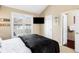 Well-lit bedroom with a dark bed frame, vaulted ceiling, a large window, and a TV mounted on the wall at 9556 Kemper Dr, Lone Tree, CO 80124
