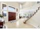 Bright foyer with soaring ceilings, grand staircase, beautiful tile floors, and large windows, creating a welcoming entrance at 9556 Kemper Dr, Lone Tree, CO 80124