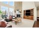 Comfortable living room with brick fireplace, large windows, plush seating, and a built-in entertainment center at 9556 Kemper Dr, Lone Tree, CO 80124