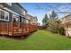 Large backyard with green grass and a wooden deck, perfect for outdoor activities at 16191 E Hinsdale Ln, Aurora, CO 80016