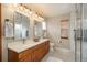 Luxurious bathroom featuring a double vanity, sleek mirrors, and a spacious glass-enclosed shower for relaxation at 16191 E Hinsdale Ln, Aurora, CO 80016