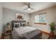 Comfortable bedroom featuring a cushioned headboard, ceiling fan, and natural light from a window at 16191 E Hinsdale Ln, Aurora, CO 80016